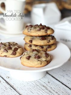 chocolate chip cookies are stacked on a white plate