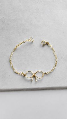 Our handmade bow bracelet is delicate and adorable. This dainty bracelet is perfect for all occasions, including weddings, bridesmaids, or everyday layering with other favorite bracelets. - Choose from 14k gold-filled or Sterling Silver - Each will include a 1/2" extender  ∙ PACKAGING∙ We would like to try to be responsible when packaging items; therefore, each order will come with one gift box only. We will ensure that each item is separated within that box and can be gifted if you choose to gift. If you would like us to box each piece of jewelry or gift separately, request this in the note to us upon checkout. ∙ JUST FOR YOU ∙ Made with love in California. We are happy to write a note to enclose your purchase. If it is a special gift, please let us know in the message box upon checkout. Elegant Adjustable Bracelets With Bow Detail, Elegant Adjustable Bracelet With Bow, Elegant Adjustable Bracelet With Bow Detail, Dainty Ribbon Jewelry For Gifts, Adjustable Bow Bracelet Gift, Adjustable Bow Bracelet As Gift, Adjustable Bow Bracelet For Gift, Delicate Bow Jewelry As Gift, Delicate Bow Jewelry For Gift