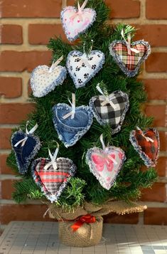 a small christmas tree with hearts hanging from it's branches and burlocks