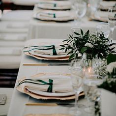 the table is set with white and green place settings