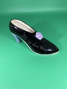 a black shoe with a flower on the top and writing on the bottom that says, it's love their shoes