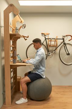 a man sitting on an exercise ball using his laptop