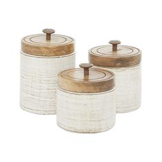 three white canisters with wooden lids