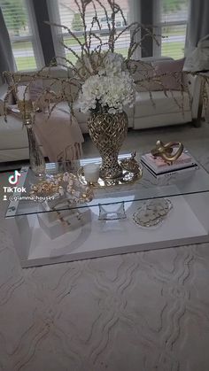 a living room filled with lots of furniture and flowers on top of a glass table