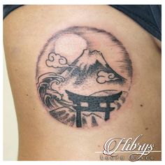 a woman with a tattoo on her stomach has a mountain and japanese symbol in the background