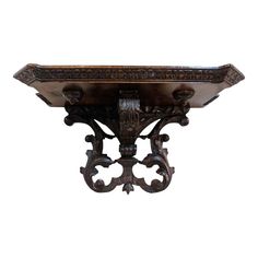 an ornate wooden shelf with carvings on the top and bottom, against a white background