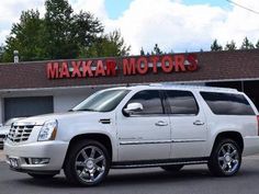 a white suv is parked in front of a building that says maxxar motors