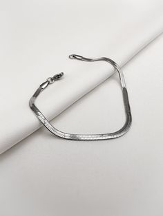 This elegant snake bracelet is made of high quality stainless steel, which is both sturdy and durable. It is perfect for everyday use or special occasions and will add a touch of style to any outfit. The bracelet is elaborately crafted and reflects the light beautifully. With a practical lobster clasp, the bracelet is easy to put on and securely fastened. This stainless steel bracelet is a timeless addition to any jewelry collection and is sure to be a popular accessory for years to come. Please Modern Metal Bracelets With Snake Chain, Trendy Metal Snake Chain Bracelet, Modern Silver Snake Chain Bracelet, Silver Metal Snake Bracelets, Silver Metal Snake Bracelet, Silver Snake Bracelet, Bracelet In Silver, Herringbone Chain, Snake Bracelet