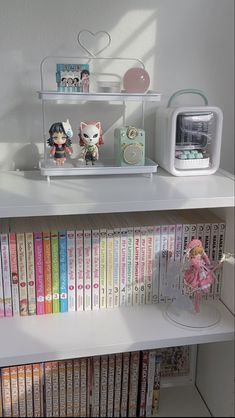 a shelf filled with lots of books on top of a white book case next to a microwave