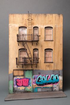 a tall building with graffiti on it's side and stairs to the second floor