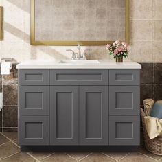 a bathroom vanity with a mirror above it and a basket on the floor next to it