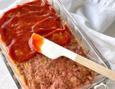 a glass casserole dish with meatloaf and marinara sauce in it