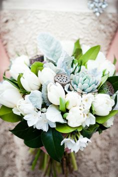 a bridal bouquet with white flowers and succulents