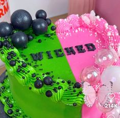 two heart shaped cakes decorated with black and pink frosting, one is green and the other is pink