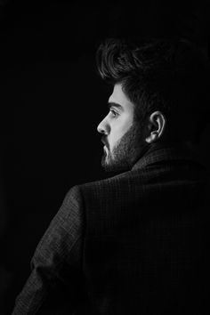 a black and white photo of a man in a suit looking off into the distance