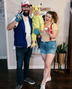 a man and woman in pokemon costumes posing for a photo with a baby on their lap