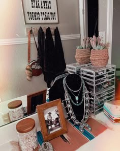 there are many necklaces on display in the bathroom mirror and other items sitting on the counter