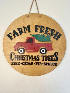 a wooden sign hanging from the side of a wall that says farm fresh christmas trees