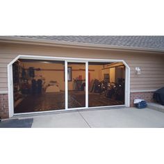 an open garage door in front of a house with bicycles on the outside and inside