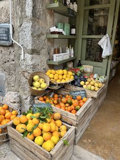 several wooden boxes filled with oranges and lemons next to a store front window