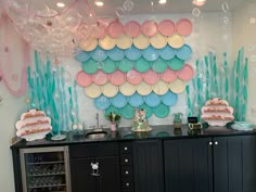 a party with balloons, plates and cake on the buffet table in front of it