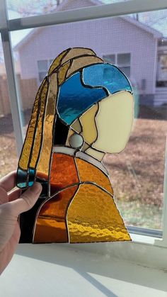 a stained glass woman's head sitting on top of a window sill