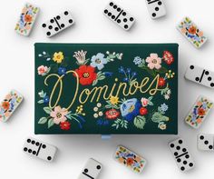 dominos are scattered around a green box with flowers and the word'douvre'spelled in cursive letters