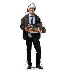 a man in a suit and tie is holding some presents while wearing a santa hat