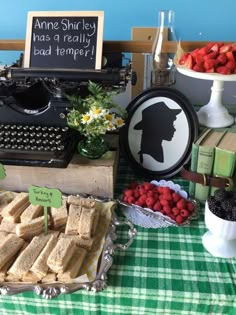 a table topped with lots of food next to a typewriter and other items on display