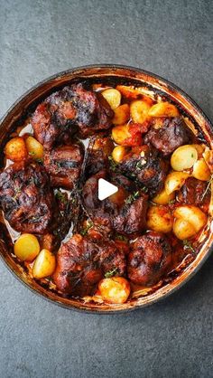 a pot filled with meat and potatoes on top of a table