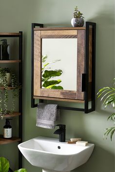 a bathroom sink sitting under a mirror next to a green wall