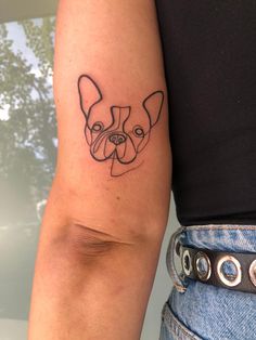 a woman's arm with a small tattoo of a dog on the left side of her arm