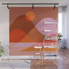 an orange and pink wall mural in a living room with a chair, table and plant