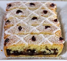 a close up of a cake on a plate with powdered sugar and chocolate chips