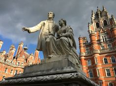 a statue of two people in front of a castle