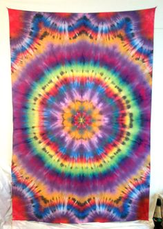 a colorful tie - dyed tapestry hanging on a wall