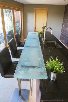 a kitchen with black counter tops and chairs