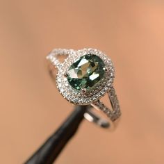 It is a green sapphire ring. The main stone is 6 mm*8 mm oval cut.weight about 1.75 carats.The basic metal is sterling silver and plated with rhodium/14k white  gold/14k rose gold/14k yellow goldYou can also go to my shop Home for more elegant rings: https://www.etsy.com/shop/godjewelry?ref=hdr_shop_menu Customization is always welcome and please feel free to contact with me if you have any design ideas! Luxury Green Sapphire Ring In Sterling Silver, Rainbow Topaz Ring, Yellow Gemstone Ring, Citrine Ring Engagement, Rainbow Topaz, Double Halo Engagement, Double Halo Engagement Ring, Mystic Topaz Ring, Green Sapphire Ring