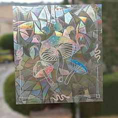 a stained glass window with an umbrella and flowers on it