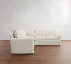 a white couch sitting on top of a hard wood floor next to a wooden floor