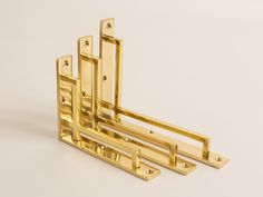 three golden metal brackets on a white background