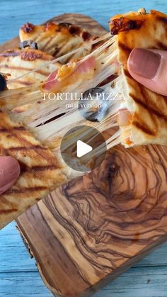 someone is holding slices of pizza on a wooden cutting board with the words tortilla pizza