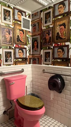 a pink toilet in a bathroom with pictures on the wall