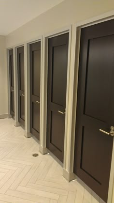 a row of brown doors sitting next to each other on top of a white tiled floor