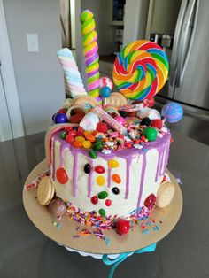 a birthday cake decorated with candy and lollipops