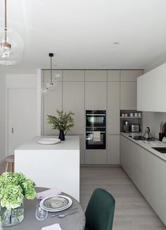 the kitchen is clean and ready to be used for dinner or lunchtime, while the dining table is set with place settings