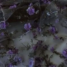 purple flowers on white fabric with green stems and leaves in the center, as if it were made out of plastic