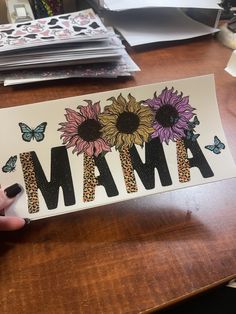 a person holding up a sticker that says mama with sunflowers and leopard print