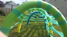 an arch made out of plastic tubes in the grass