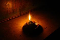 a lit candle sitting on top of a wooden table